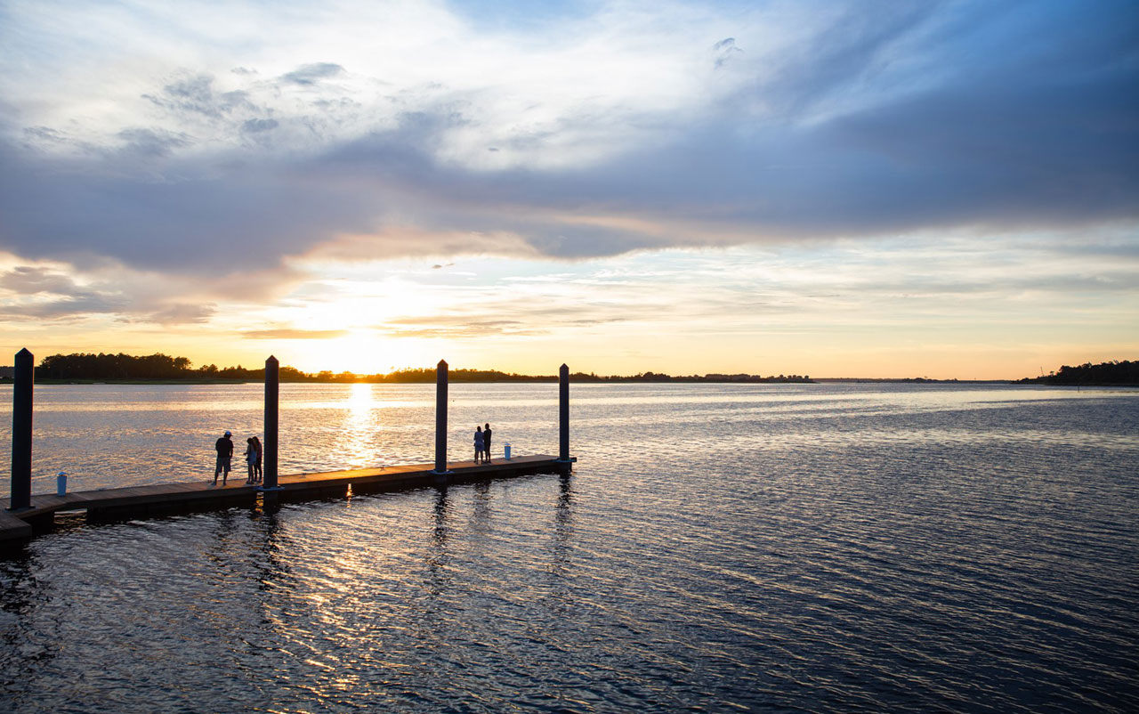 People on dock during sunset at Riverlights in Cape Fear