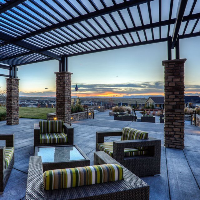Exterior area of Inspiration community center with patio cover and chairs at sunset