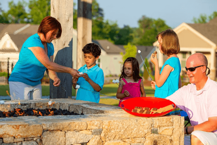 Family of five enjoying s'mores at a firepit